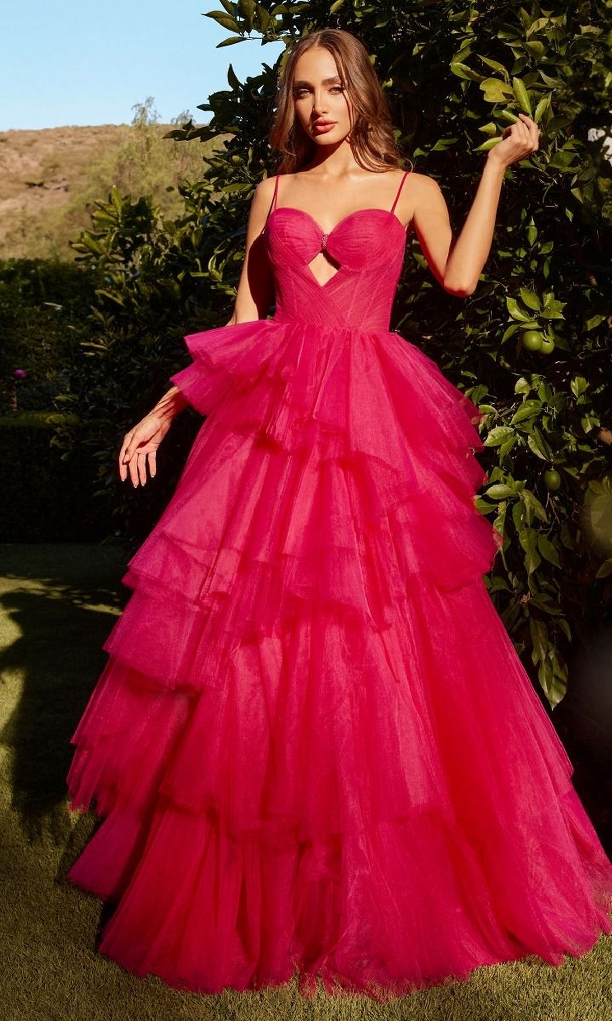Outdoors, a woman wears the Bright Cut-Out Long Tiered Prom Ball Gown A1238, featuring a vibrant hue and elegant tiered design.